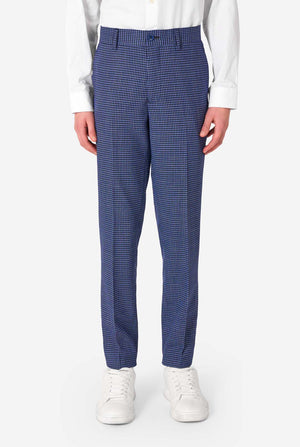 A young boy stands smiling while wearing a formal navy plaid suit jacket over a white button-down shirt. The suit features a subtle check pattern. Close up of the pants