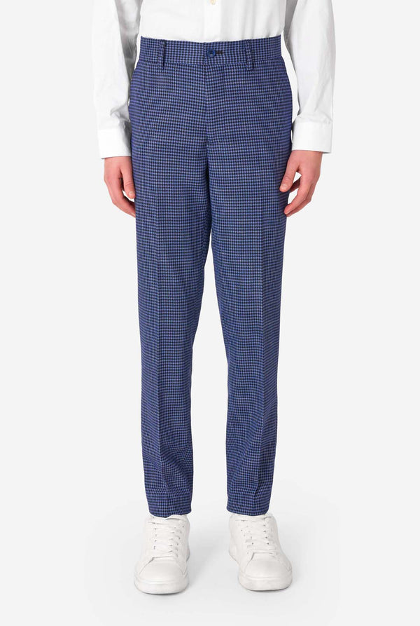 A young boy stands smiling while wearing a formal navy plaid suit jacket over a white button-down shirt. The suit features a subtle check pattern. Close up of the pants