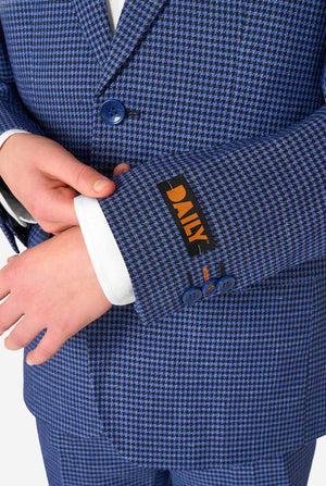 A young boy stands smiling while wearing a formal navy plaid suit jacket over a white button-down shirt. The suit features a subtle check pattern. Close up of the sleeves