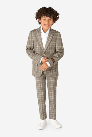 A boy wearing a tan checkered suit with a white dress shirt. The suit has a modern fit with two buttons and flap pockets. He stands against a plain white background. Full body image.
