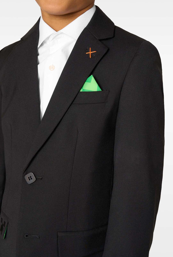 Black suit jacket with a white shirt and green pocket square on a plain background