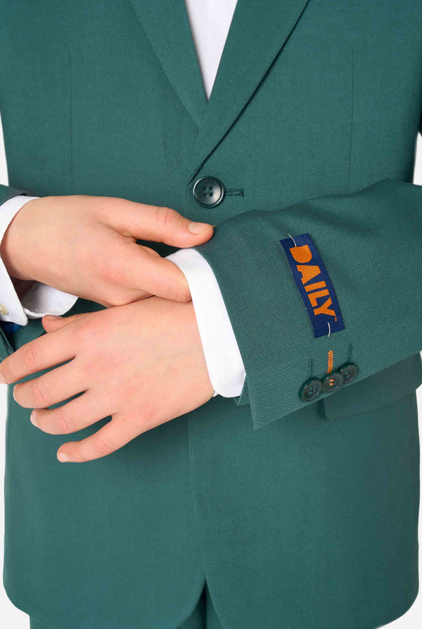 Teen boy wearing a stylish dark green suit with a white dress shirt, smiling confidently. Perfect formal outfit for boys' special occasions, weddings, and parties. Sleeve close up.