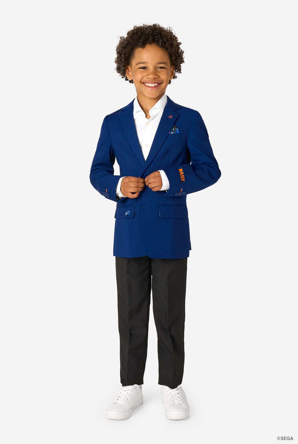 Child wearing a blue blazer with a white shirt and black pants on a white background