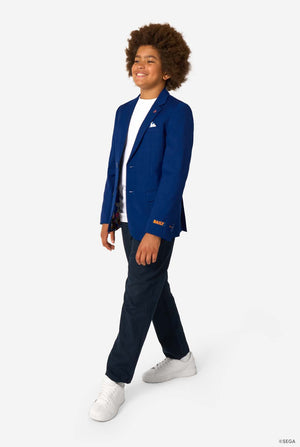 Person wearing a blue blazer with a logo, white shirt, navy pants, and white sneakers on a white background.