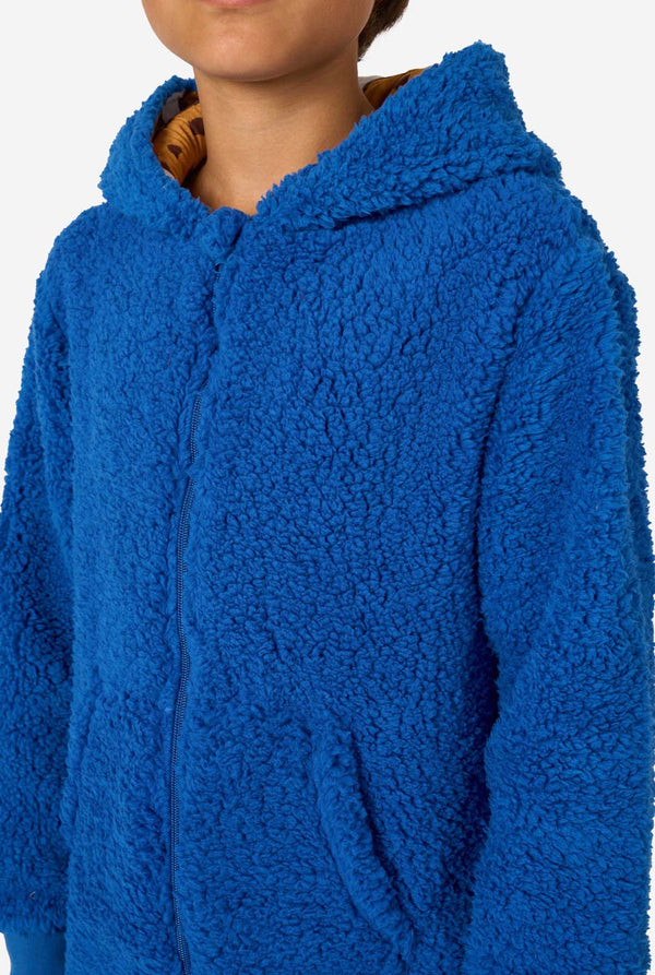 A kid is wearing a blue sesame street onesie resembling Cookie Monster. Close up of the chest