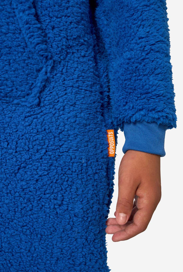 A kid is wearing a blue sesame street onesie resembling Cookie Monster. Close up of the sleeves