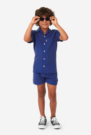 Boy wearing dark blue summer set, consisting of shorts and shirt, full body image