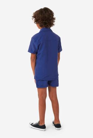 Boy wearing dark blue summer set, consisting of shorts and shirt, view from the back