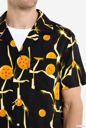 Man wearing black Hawaiian shirt with Dragon Ball Z print, showings Dragon Balls and lighting. He is also wearing a white t-shirt and black pants. Chest close up.