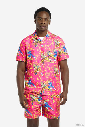 Man wearing pink summer set consisting of shirts and shorts. Summer set has Dragon Ball Z Goku and Vegeta fighting print.