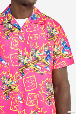Man wearing pink summer set consisting of shirts and shorts. Summer set has Dragon Ball Z Goku and Vegeta fighting print. Chest close up.