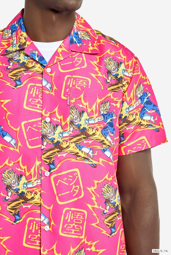 Man wearing pink summer set consisting of shirts and shorts. Summer set has Dragon Ball Z Goku and Vegeta fighting print. Chest close up.