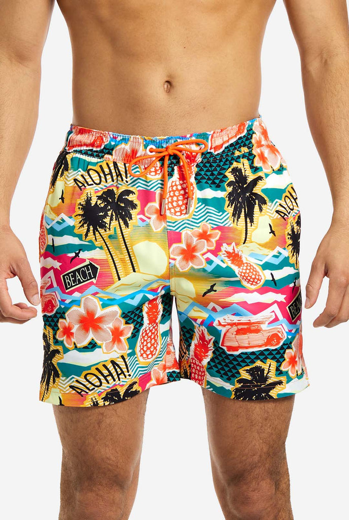 Man wearing swim trunks with tropical Hawaiian print, close up