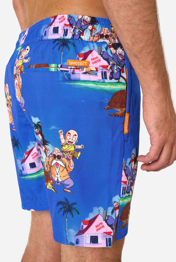 Men's blue Dragon Ball-themed swim shorts featuring Goku, Krillin, Master Roshi, and other characters at Kame House. Perfect for anime fans at the beach or pool. 