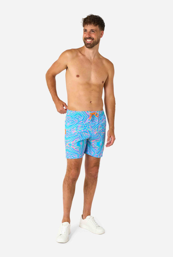Man wearing a men's vibrant holographic swim shorts with a mesmerizing blue, pink, and purple swirl design. Eye-catching and stylish swimwear for summer fun.