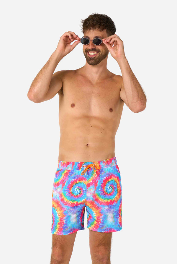Men's rainbow tie-dye swim shorts with a bold, colorful spiral pattern. A fun and trendy choice for beach days and pool parties.