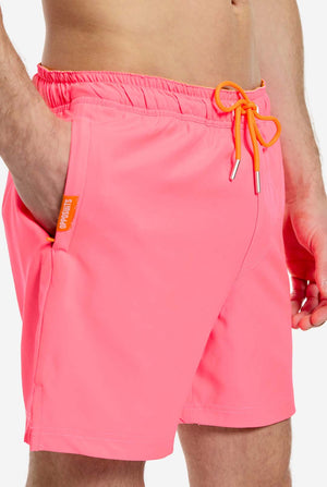 Man wearing Neon Pink Power swim trunks for men, close up