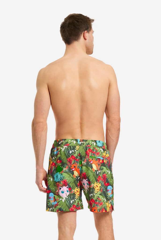 Man wearing swim trunks with Pokemon forest print, view from the back
