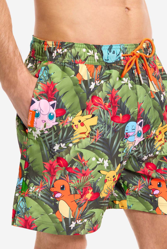 Man wearing swim trunks with Pokemon forest print, close up