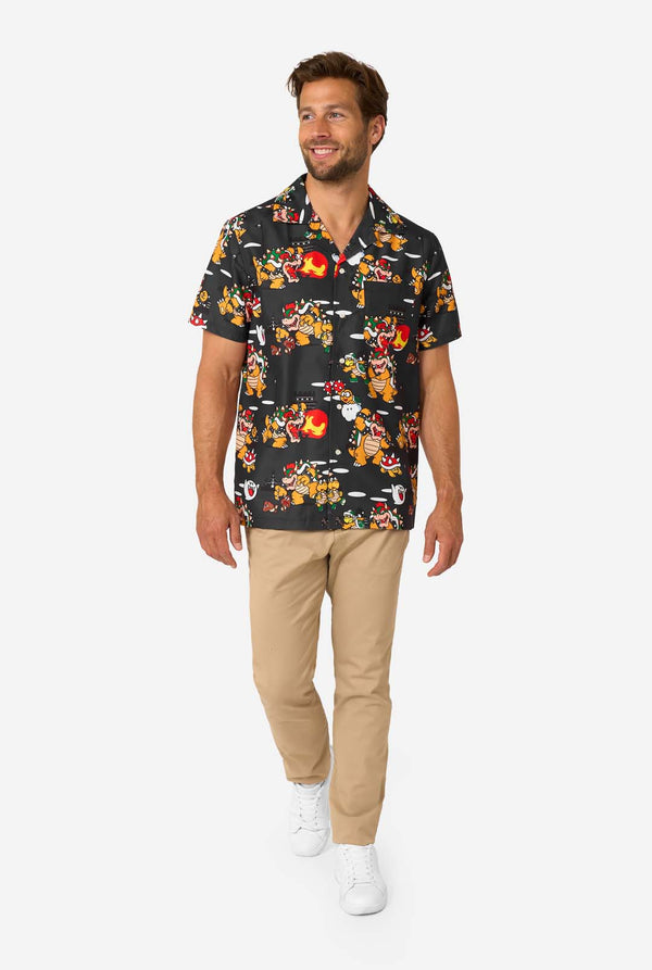 Full-body view of man in Bowser’s Mayhem shirt paired with beige pants and white sneakers.