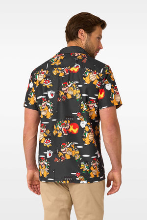 Man wearing short-sleeve black Bowser’s Mayhem shirt with colorful Bowser print. View from the back
