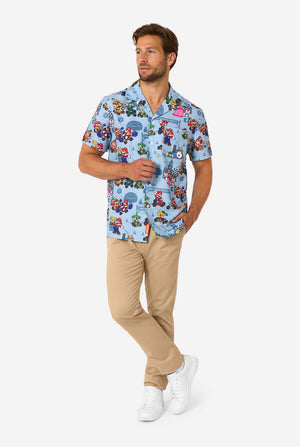 Man wearing light blue short-sleeve Mario Kart shirt with colorful character print. Full body image.
