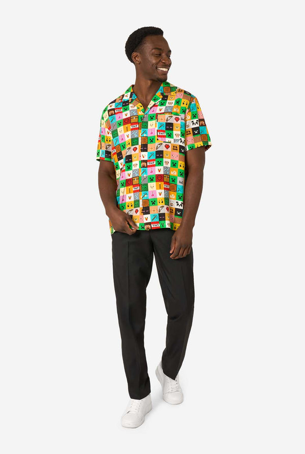 Man wearing a colorful Minecraft Hawaiian shirt featuring pixelated blocks, characters, and items from the game, paired with black pants, standing against a plain white background. Full body image