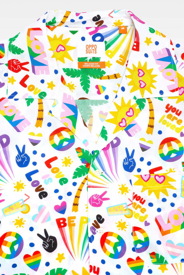 Image of a white Hawaiian shirt with a rainbow pride print. The Print consists of peace symbols, hearts, and other icons. 