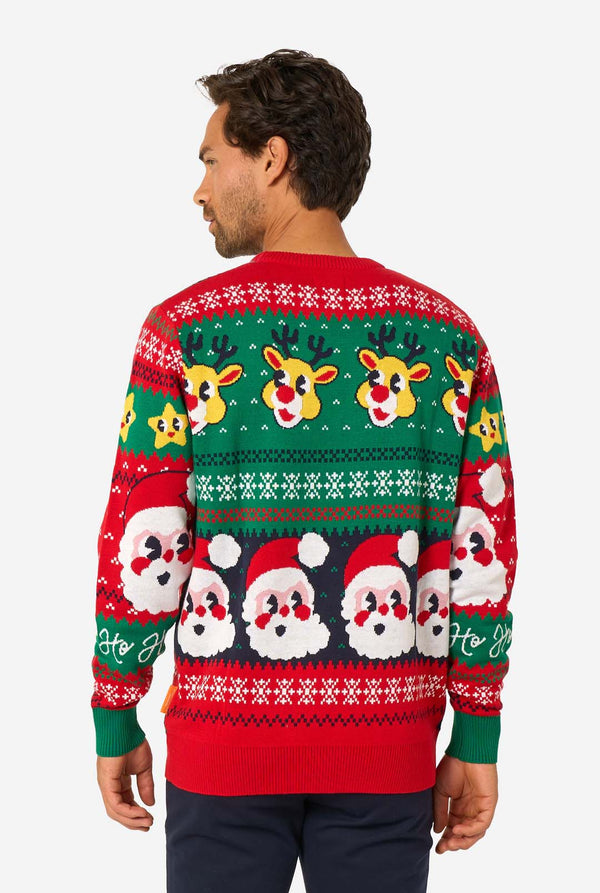Smiling man wearing a colorful knitted Christmas sweater featuring Santa Claus, Rudolph, and the text “So Jolly.” View from the back.