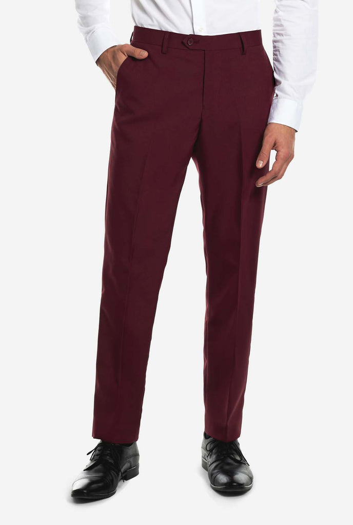 Man wearing burgundy red Christmas suit with vintage Christmas print, pants view