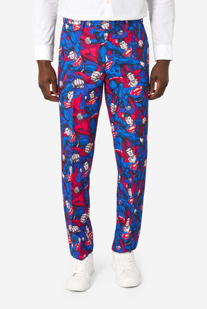 A man wearing a Superman themed suit with a red tie and a white shirt on a white background. Close up of the pants