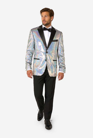 Man in a holographic silver sequin tuxedo with black satin lapels, white shirt, and black bow tie, walking forward in black trousers and dress shoes.