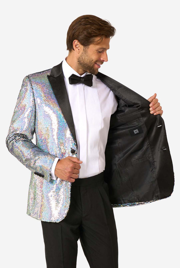 Man smiling while holding open a holographic silver sequin tuxedo to reveal a solid black interior lining with an OppoSuits label.
