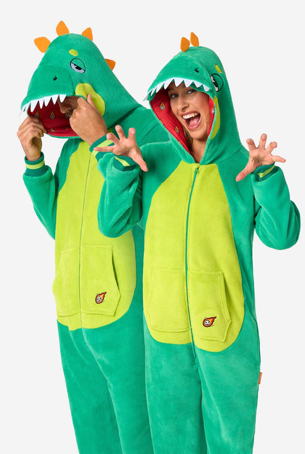 A man and woman are wearing a green dinosaur adult onesie featuring playful hood details and cozy, soft material, perfect for lounging or costume events.
