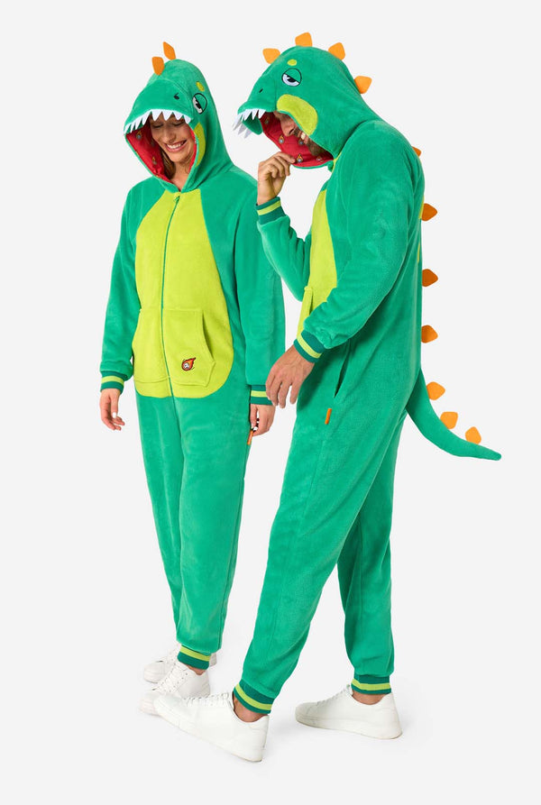 A man and woman are wearing a green dinosaur adult onesie featuring playful hood details and cozy, soft material, perfect for lounging or costume events.
