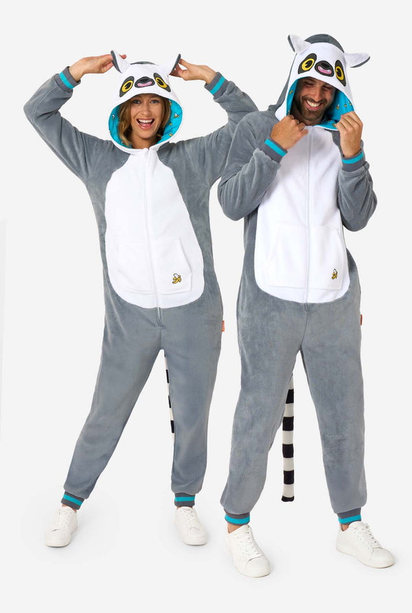 A man and women are wearing a grey and white lemur adult onesie featuring playful hood details and cozy, soft material, perfect for lounging or costume events. Including black and white tail. The hood are on their heads. Full body image.