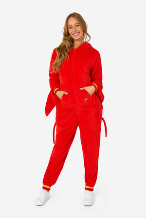 A women is wearing a bright red lobster-themed adult onesie featuring playful hood details and cozy, soft material, perfect for lounging or costume events. including stitched gloves as claws. Her hood is on her back.