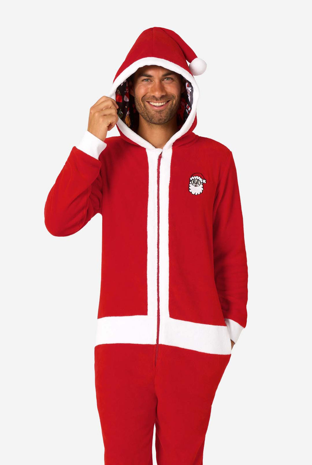 A smiling man models a cozy, red and white, hooded christmas onesie that resembles a Santa onesie.