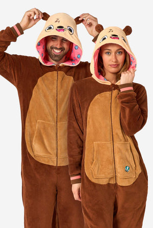 A smiling man and a woman are wearing a brown adult onesie designed as an otter. The onesie features a hood with ears, a cute face, and playful otter details, perfect for cozy lounging or costume parties.