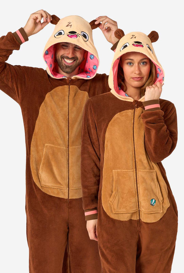 A smiling man and a woman are wearing a brown adult onesie designed as an otter. The onesie features a hood with ears, a cute face, and playful otter details, perfect for cozy lounging or costume parties.