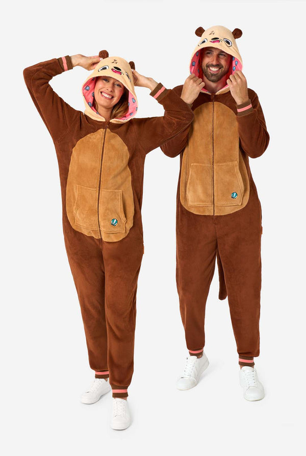 A smiling man and woman are wearing a brown adult onesie designed as an otter. The onesie features a hood with ears, a cute face, and playful otter details, perfect for cozy lounging or costume parties. Full body image. 