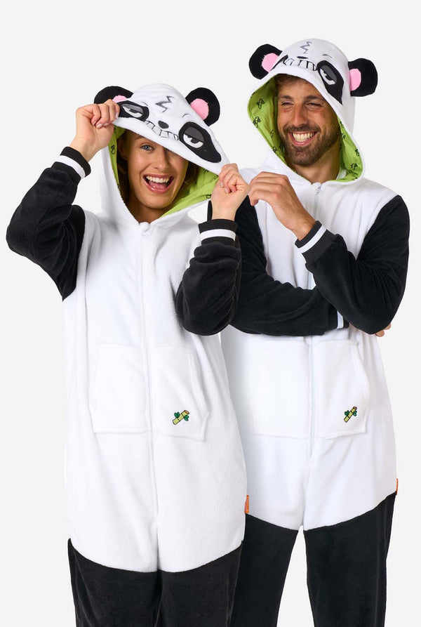 A man and woman are wearing a panda-themed adult onesie. This cozy onesie features black and white panda colors with a playful hood showcasing panda ears and a cute face. Perfect for lounging or fun costume occasions. 