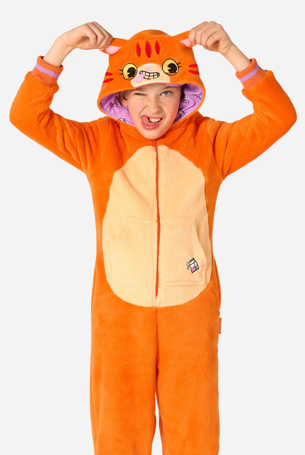 Child wearing a playful unisex kids onesie designed as a red-orange cat, featuring a hood with a cartoon cat face, ears, and a light beige belly panel, making a silly face against a plain background.