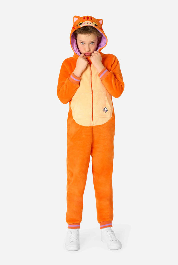 Child wearing a playful unisex kids onesie designed as a red-orange cat, featuring a hood with a cartoon cat face, ears, and a light beige belly panel, making a silly face against a plain background. Full body.