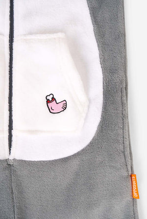 Close-up of the white pocket area of the onesie, showing an embroidered pink chicken leg and the orange Opposuits label on the side seam.