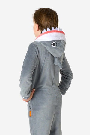 Three-quarter rear view of a child in a grey shark onesie, showcasing the embroidered shark eyes and fin details on the hood.