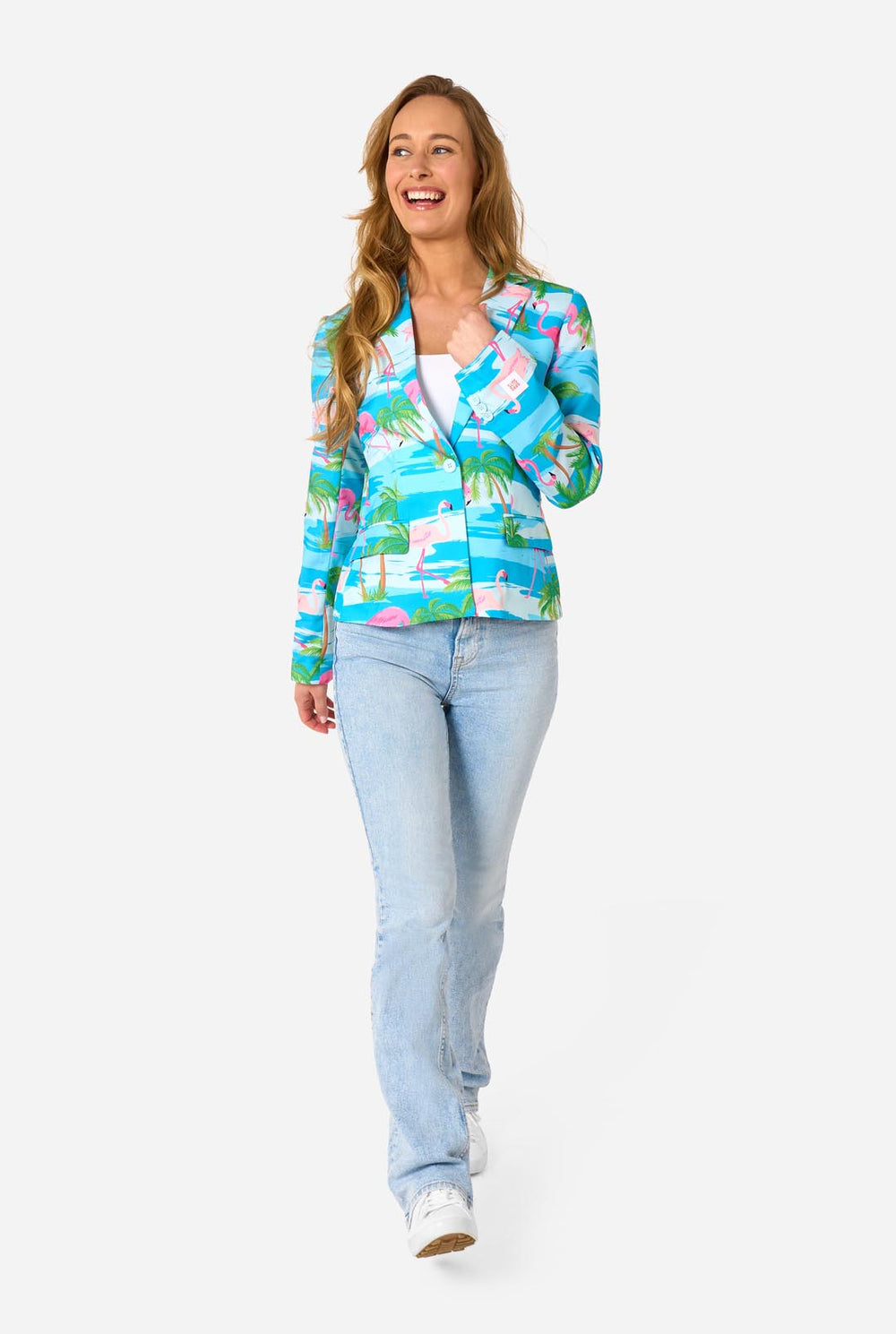 Image with a light background and a woman wearing a light blue blazer with tropical flamingo print and jeans.