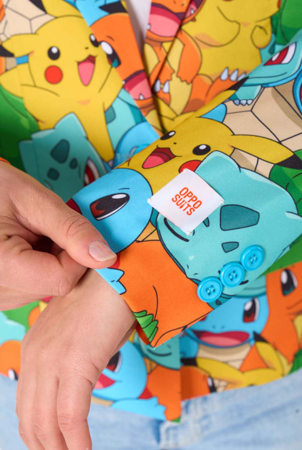 Women wearing a multi colored pokemon blazer, featuring characters such as pikachu, squirtle, charmander and bulbasaur. Close-up sleeves.