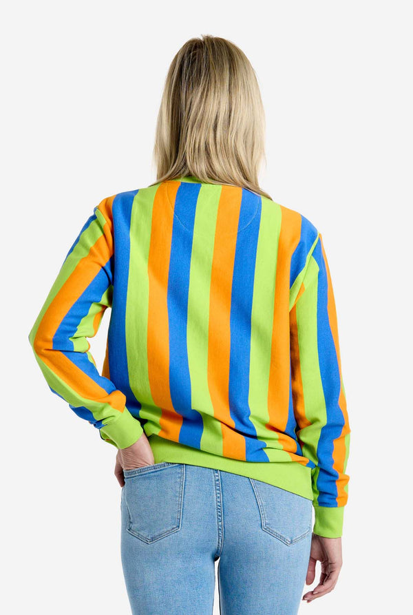 Person wearing a colorful striped sweater with a plain background