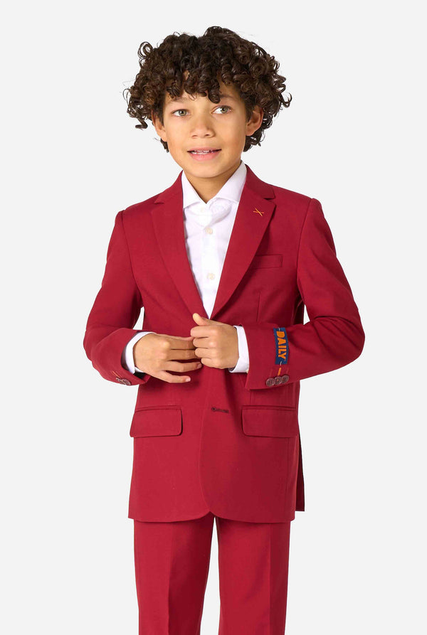 Kid wearing a stylish burgundy red suit with a white dress shirt, looking confidently. Perfect formal outfit for boys' special occasions, weddings, and parties.